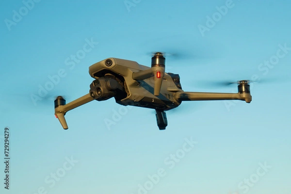 Fototapeta Detailed plan of drone with large sensors and multifunctional camera, with powerful zoom and thermal, for rescue and surveillance, horizontal view, flying in the blue sky