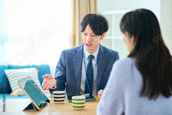 Fototapeta 女性に向かって話すスーツ姿の男性