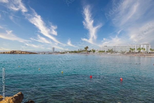 Fototapeta Vacation resort of Ayia Napa. A paradise for vacationers. A sunny day with a blue sky and white clouds. Panoramic view of the hotels and Nissi beach.
