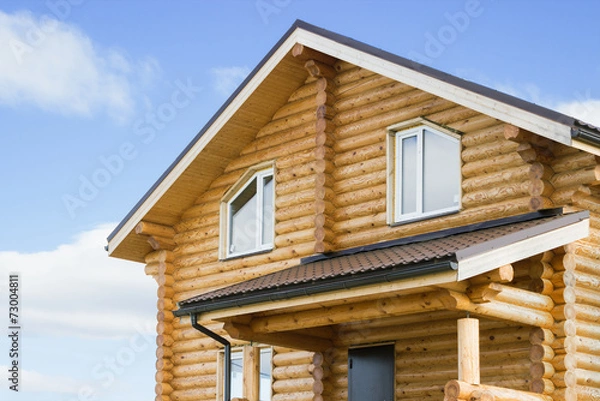 Fototapeta Fragment of a new log cabin against the sky