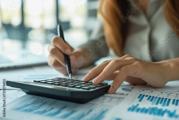 Fototapeta Business women use calculators to calculate investment charts at work. AI Generated