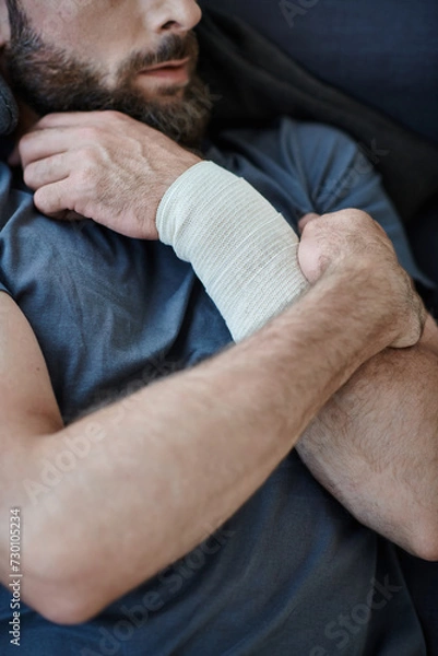 Obraz cropped view of depressed man with bandage on arm after attempting suicide, mental health awareness