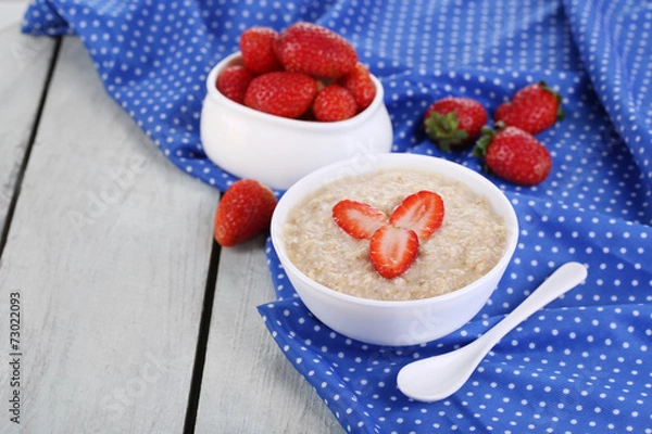 Obraz Tasty oatmeal with strawberry on table close-up