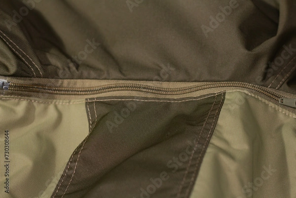 Fototapeta Zipper on beige workwear protective clothing in close-up.