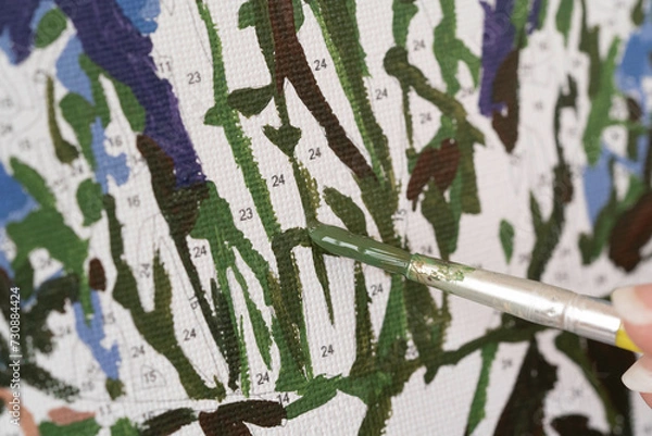Obraz A photo of a picture that is colored by numbers in the process of coloring with a brush