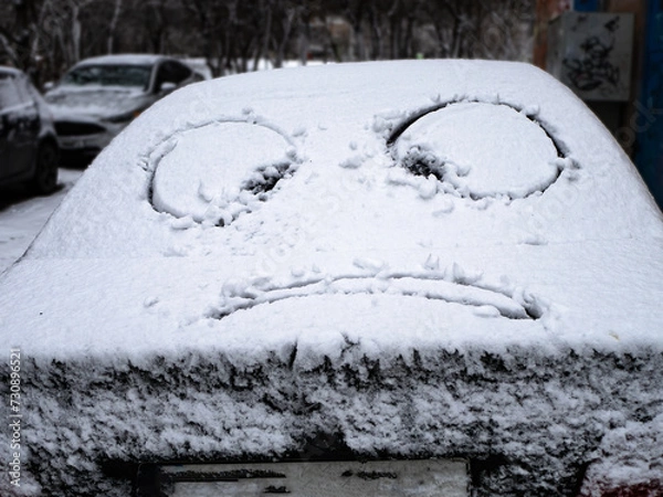 Fototapeta snowy car with drawn eyes. the problem of snowy roads
