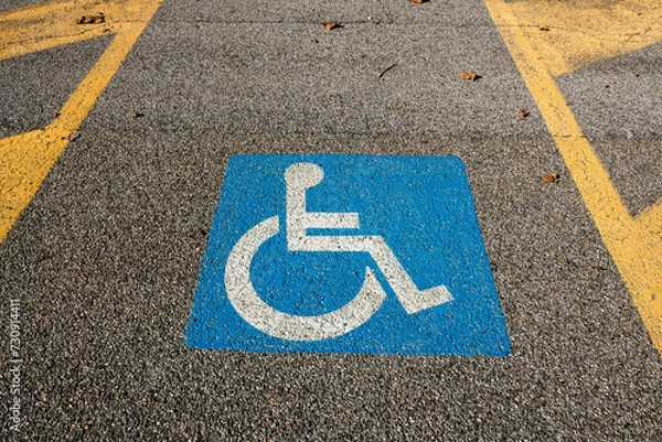 Fototapeta disabled space symbol, parking for disabled people, symbol printed on the asphalt, parking space reserved for cars for disabled people and their companions, road sign