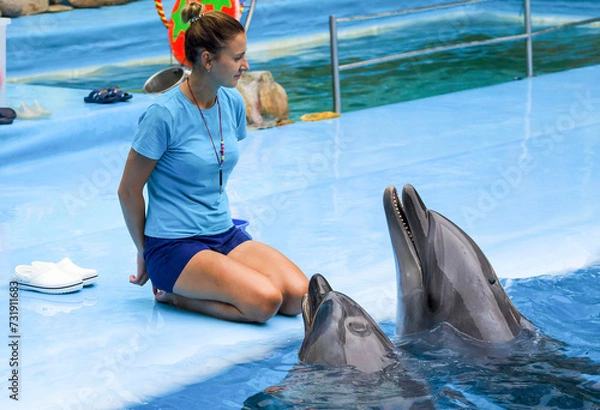 Obraz girl, trainer with  dolphins.
