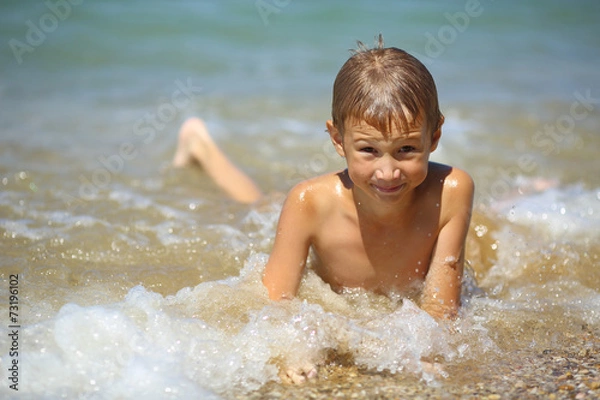 Fototapeta kid in the foam of waves