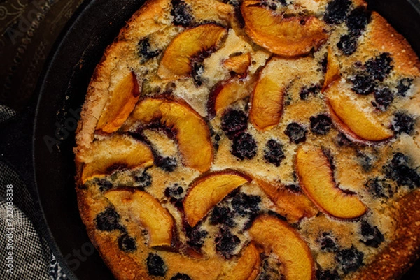 Fototapeta top down view of blackberry peach Flaugnarde (similar to Clafoutis) in cast iron pan