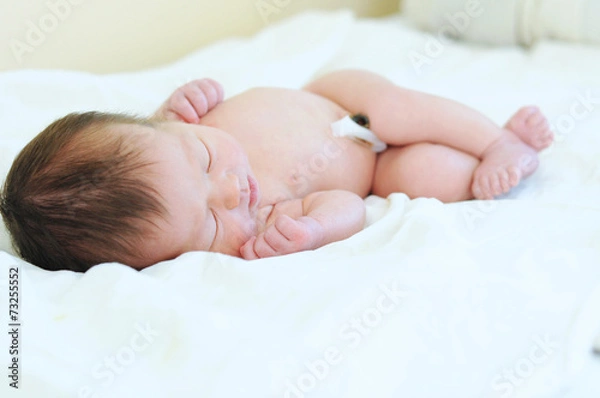 Obraz Newborn baby with umbilical cord sleeping undressed