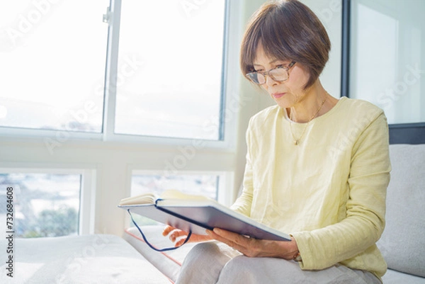 Fototapeta 窓際で読書する女性