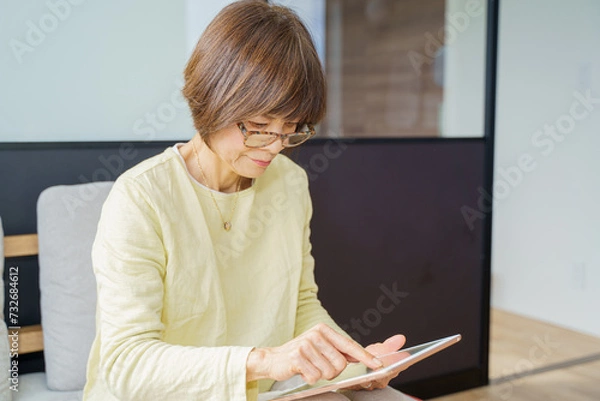 Fototapeta タブレットでリモートワークする女性