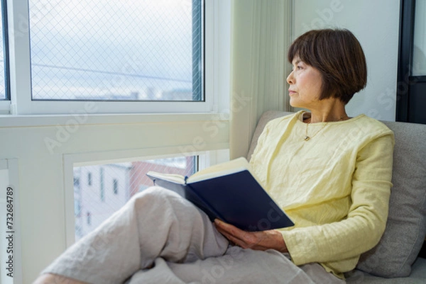 Fototapeta 窓辺で外を眺めるシニア女性