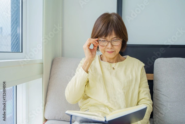 Fototapeta メガネかけて本を読むシニア女性