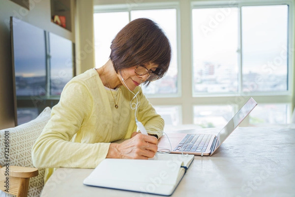 Fototapeta パソコンでリモート会議にでるシニア女性