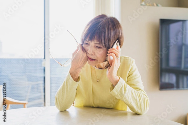 Fototapeta スマホでサポートセンターに問い合わせするシニア女性