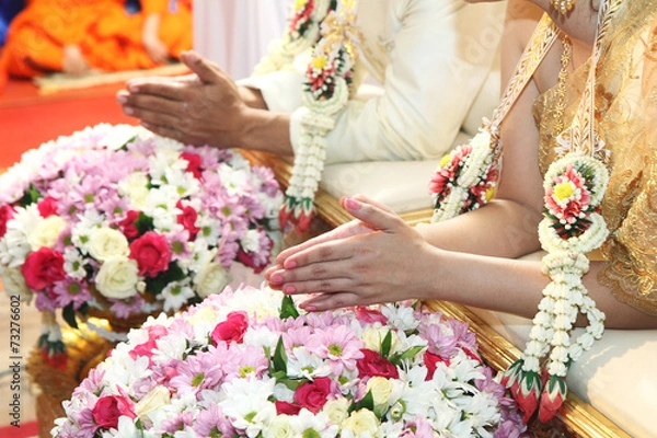 Obraz Hands pouring blessing water into bride's hands inThai ceremony.