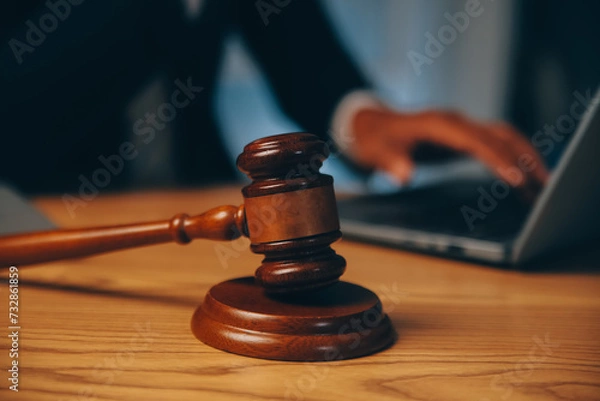 Fototapeta Judge gavel with Justice lawyers having team meeting at law firm background. Concepts of Law and Legal services.