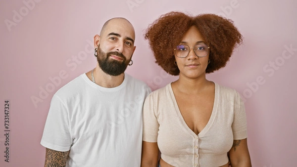 Fototapeta Beautiful couple in love standing relaxed over isolated pink background, expressing their cool lifestyle