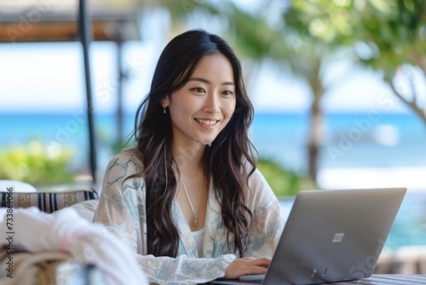 Obraz 海の近くでパソコン作業をする日本人女性のリモートワーカー（フリーランス・ノマド・テレワーク）