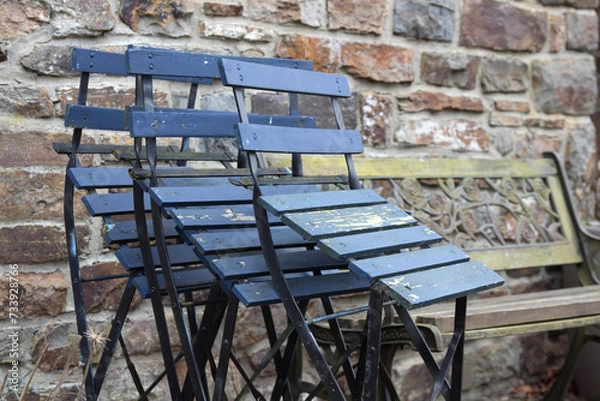 Obraz Gartenstühle im Herbst an einer Mauer