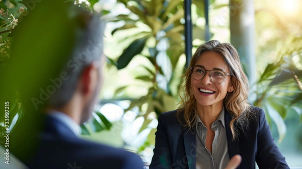 Fototapeta Financial advisor and client in a peaceful office with plants and sunlight