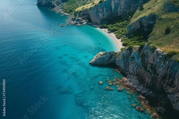 Fototapeta Drone shot of turquoise waters along a rugged coastline