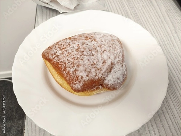 Obraz Donut with powdered sugar on the plate