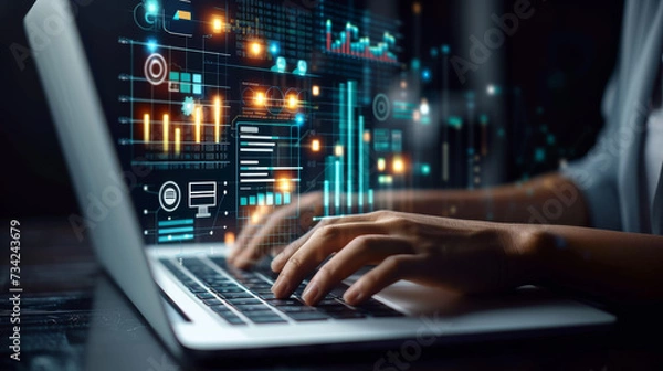 Fototapeta person's hands are seen typing on a laptop keyboard, with futuristic digital graphics of charts, graphs, and data analytics floating above the computer screen.