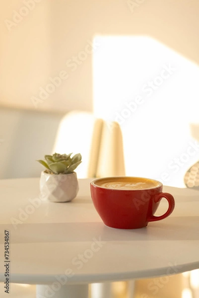 Fototapeta A Red Cup of Tulip Latte art Coffee on the table in the morning time
