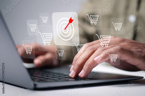 Fototapeta Targeting to increasing sales in ecommerce business. Person use laptop with target and shopping cart icon. Sale volume increase make business success.