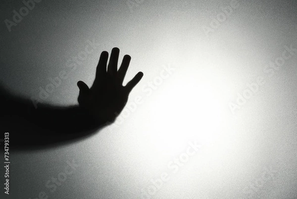 Fototapeta Silhouette of ghost behind glass against light background, closeup. Space for text