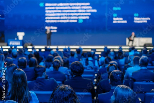 Obraz Focused view on corporate audience listening to a presenter at a professional conference event.