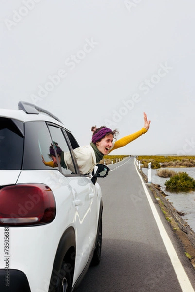 Fototapeta Woman in car travelling, car rental or vacation, invitation to travel