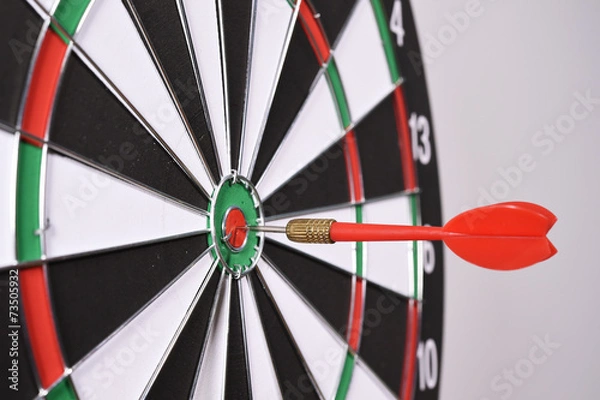 Fototapeta Dartboard with red darts on gray background.