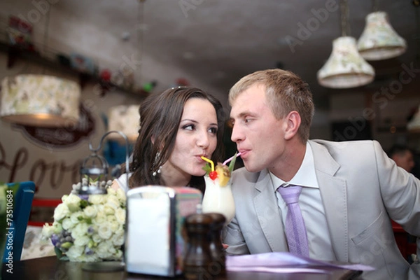 Obraz Жених с невестой пьют вместе коктейль