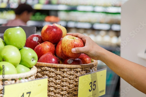 Obraz Hand holding apple in department store