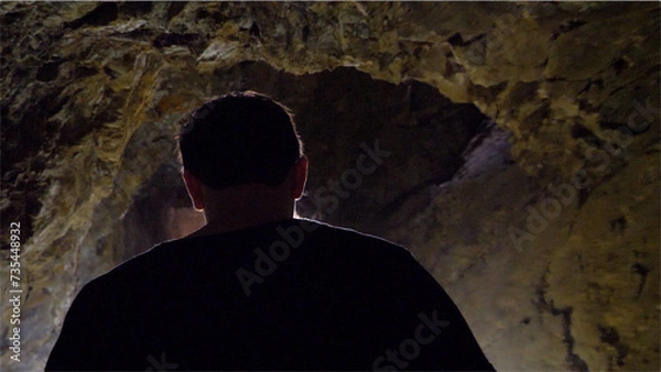 Fototapeta Man exploring a cave