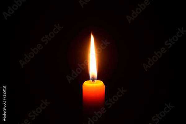 Obraz Orange candle burning on a black background
