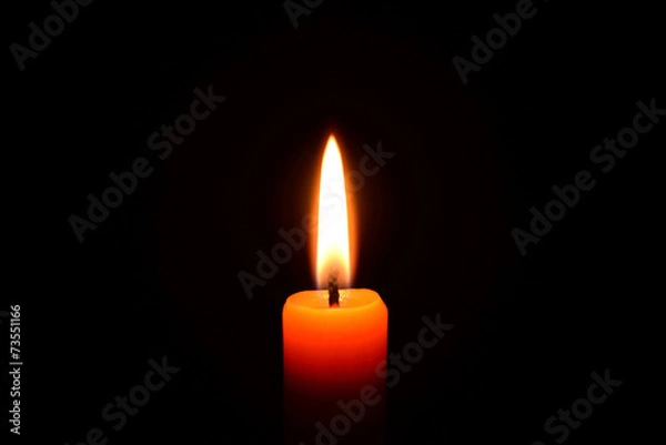 Obraz Orange candle burning on a black background
