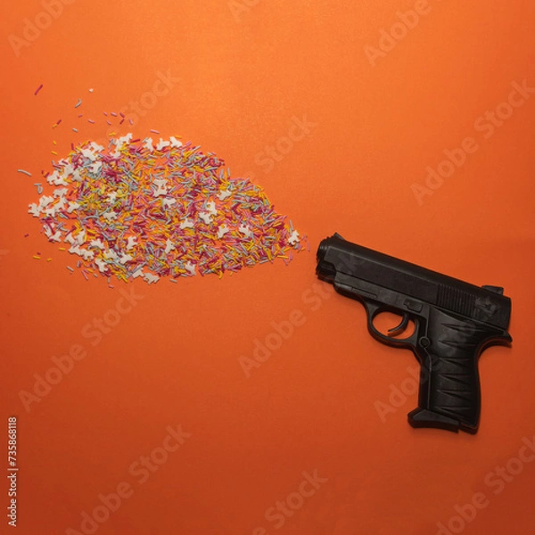 Fototapeta Pistol shooting sprinkles creative concept. Flat lay. 