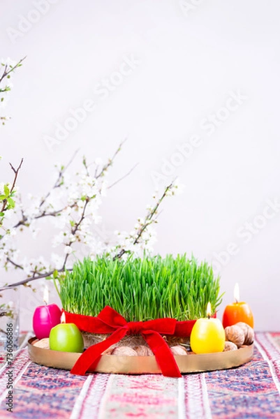 Fototapeta Beautiful Novruz tray on rug with semeni - wheat grass with red ribbon, festive candles on national Azerbaijani carpet table cloth with blooming branch,Spring equinox and new year celebration in Baku.