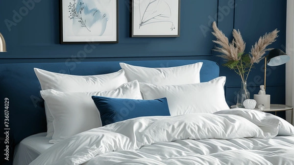 Fototapeta White pillows, duvet and duvet case on a blue bed. White bed linen on a blue sofa. Bedroom with bed and bedding and poster frame mock up on the wall. Left side view. Made with generative ai