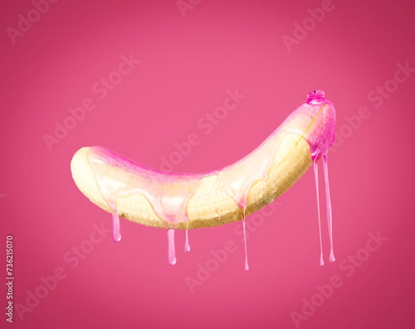 Fototapeta Peeled banana dripping pink gel on pink background.
