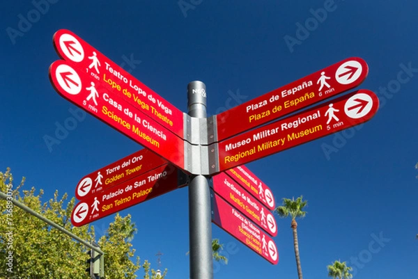 Fototapeta Signpost in Seville directing visitors to various sights in the city of Seville, Spain