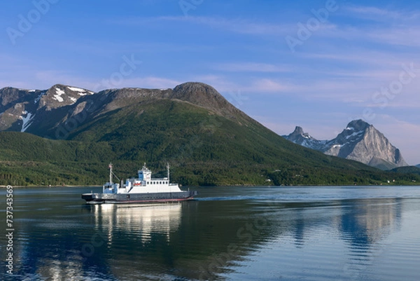 Fototapeta A ferry journey across a glassy fjord, bordered by verdant slopes and towering peaks under a clear blue sky, captures the essence of Nordic serenity