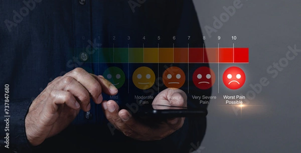 Fototapeta Man using smartphone to complete pain measurement assessment on colorful icons, virtual reality screen Emotions range from happy blue to crying red. medical technology and future concepts