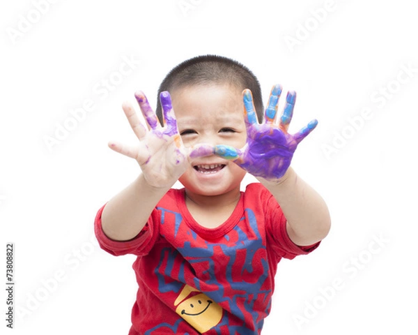 Fototapeta A  happy little boy with paints on hands on white background