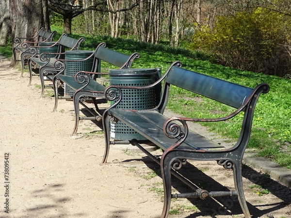 Fototapeta A row of green benches with litter bins in a park in Copenhagen